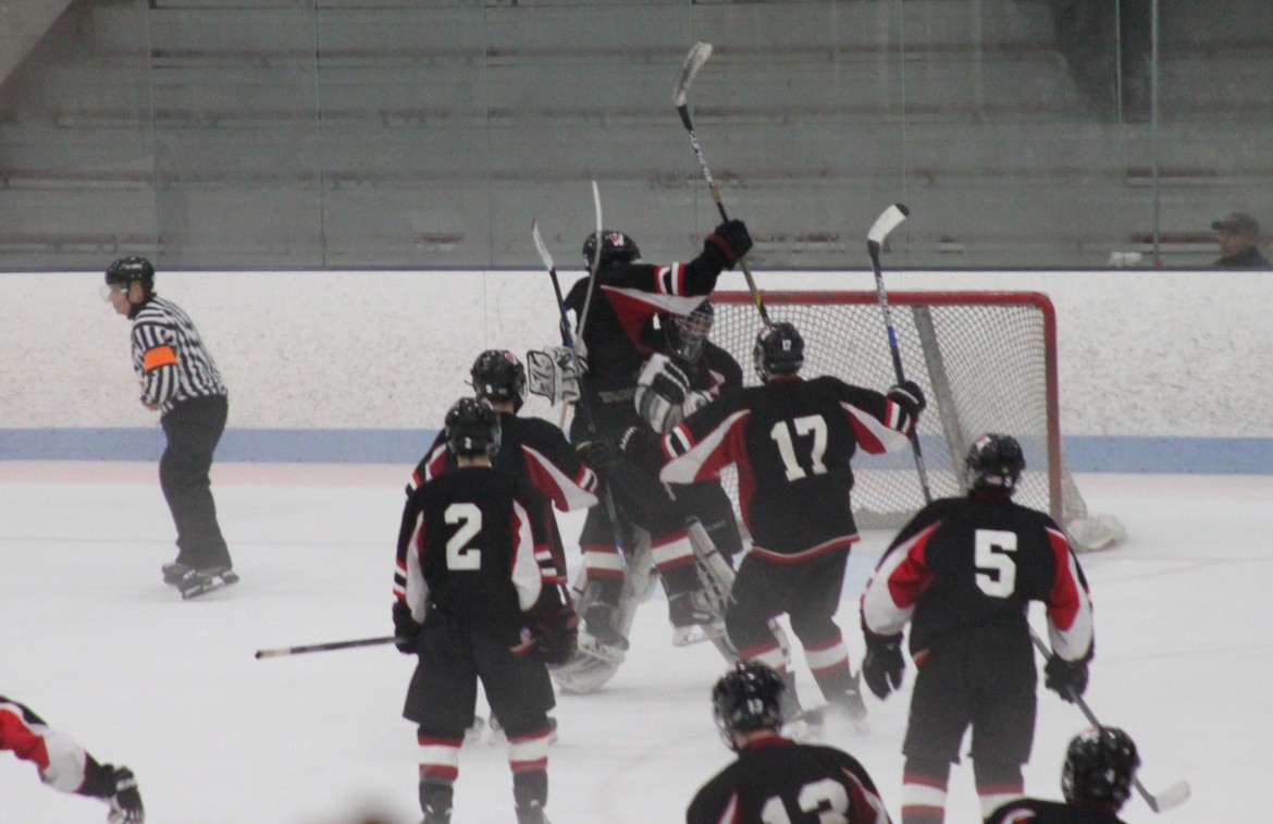 Watertown's boys hockey team converges on goalie Jason Hughes after we made the game-winning save in the shootout against Shawsheen Tech.