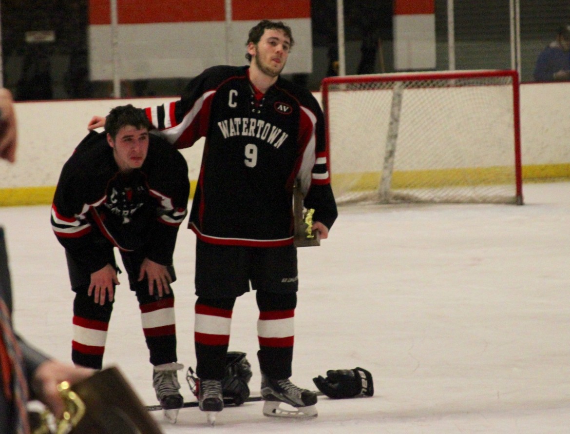 Watertown seniors Tyler Poulin, left, and Tyler Gardiner watch as Wayland collects the North Section championship trophy after the Raiders lost 2-1 in overtime.