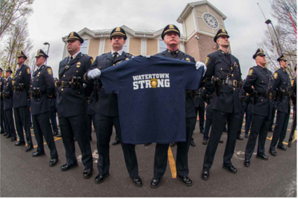 A photo from Joshua Tousters book, "Aftermath," showing members of the Watertown Police Department holding the T-shirt the planned to give to Vice President Joe Biden at the memorial for MIT Police Officer Sean Collier.