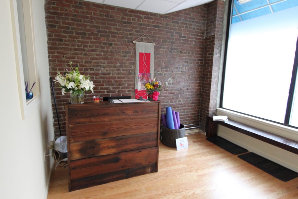 The front desk at Simply Yoga was built out of reclaimed wood by James Kinsella of Brookline.