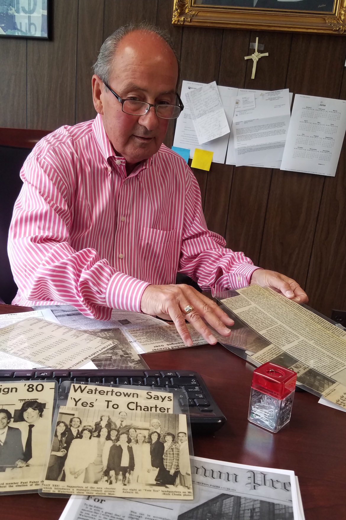 John Airasian looks through his press clippings from the Watertown Charter effort in his office at Eastern Clothing.