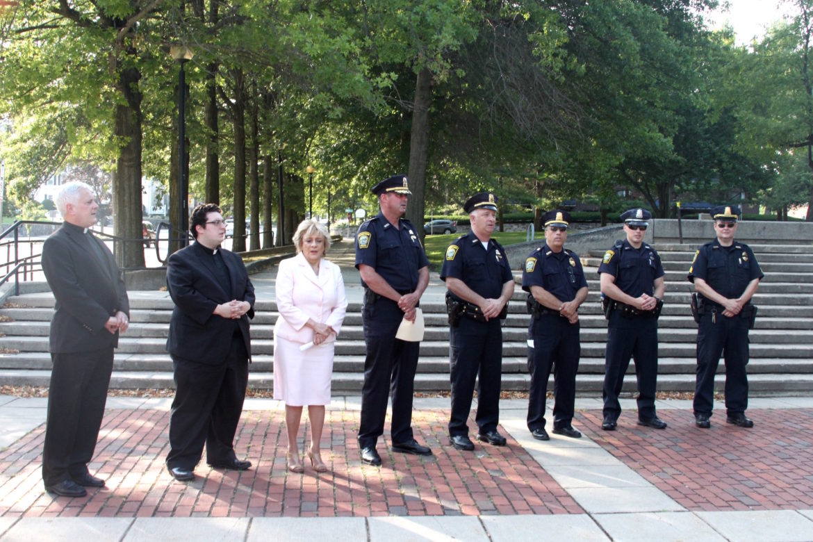 Members of the Watertown Police Department, including Chief Michael Lawn, center, received thanks from residents at the Support Our Watertown Police event. Marilyn Petitto Devaney, third from left, organized the event and Father Kevin Seppe, left, led a prayer.