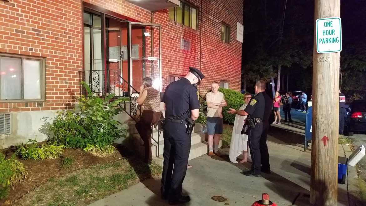 Watertown Police officers speak with residents who were evacuated from 10 Riverside St. due to high levels of carbon monoxide. Six residents  were sent to hospital.