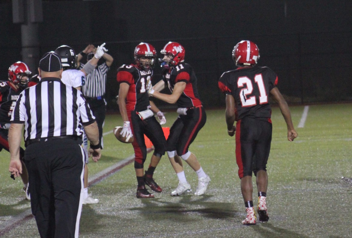 Sophomore Yoseph Hamad, left, is congratulated by junior John Korte, after intercepting a Plymouth South pass in the end zone.