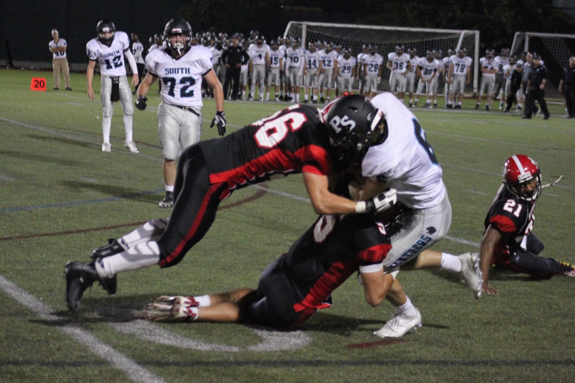 Watertown defenders junior Ben Landry and senior Isaac Huff stop Plymouth South's John Quindley in Friday night's 24-6 win for the Raiders. 