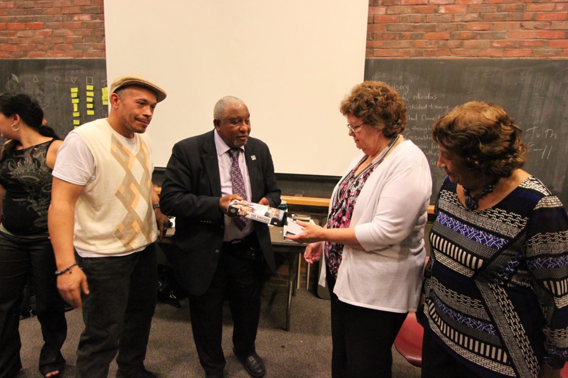 Civil Rights leader Dr. Bernard Lafayette presents Watertown Superintendent Jean Fitzgerald with a book during the celebration of the end of the Kingian Nonviolence training. With them are Lafayette's wife, Kate, (right) and Nonviolence trainer Jonathan "Globe" Lewis, left.