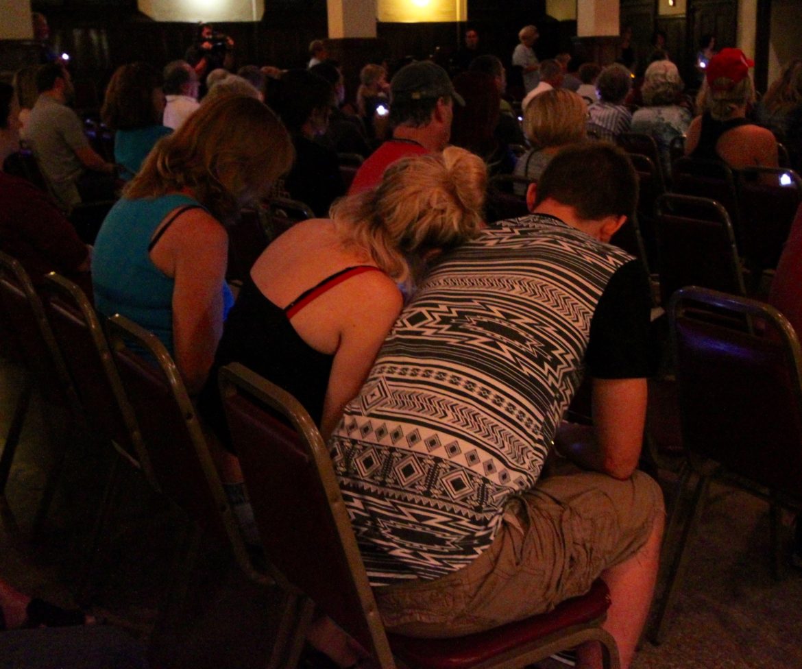 People comfort each other as the names of those who died from addiction were read during the Watertown Overcoming Addiction Candlelight Vigil and Memorial.