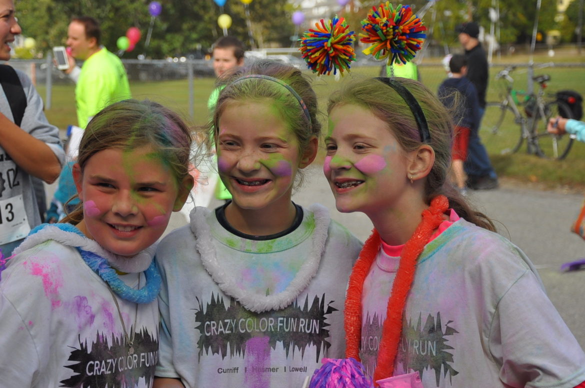 Three girls covered in color powder after the Crazy Color Race.