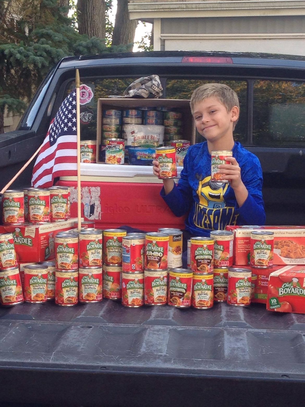 Watertown's Brady Gleason sits with the cans he collected during his birthday party. They will be donated to Operation American Soldier.