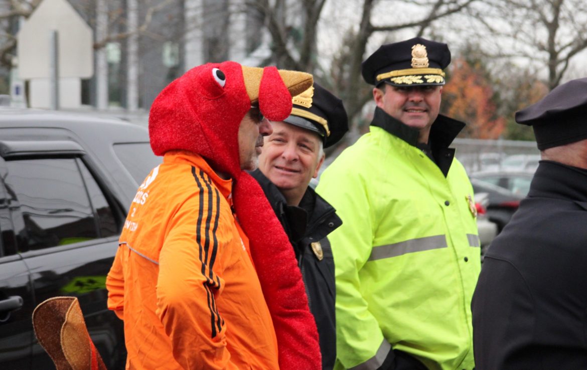 Watertown Police Chief Michael Lawn, right, and Police Capt. Ray DuPuis speak with Bill Urquhart of Watertown, who ran in his turkey costume.