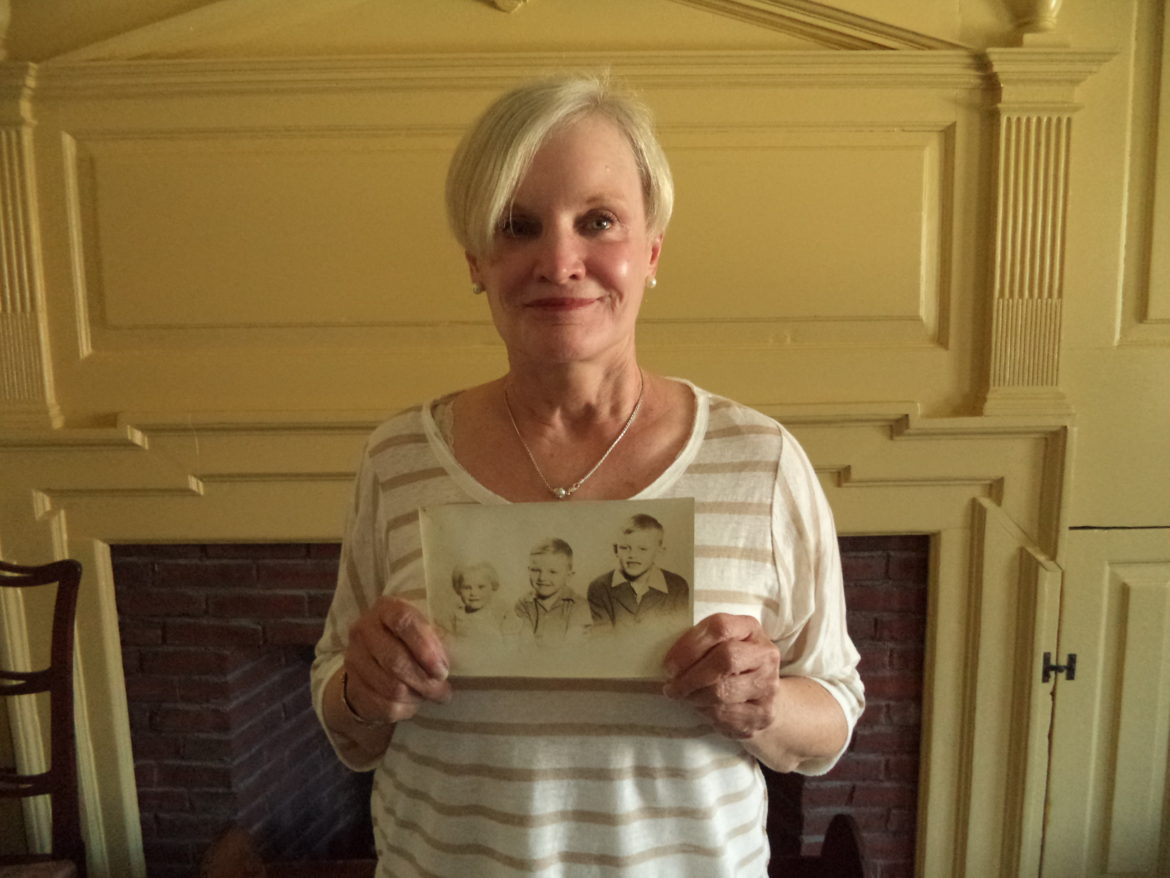Millie McLaughlin Leitner holding the photo of herself and her brothers that was given to the Watertown Historical Society by the son of a local photographer.